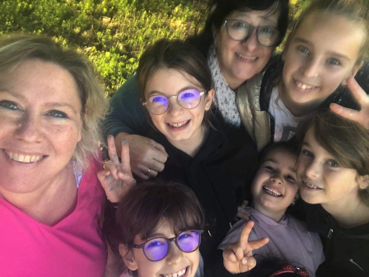 La formatrice entourée d'enfants et d'une adulte souriants lors d'une session